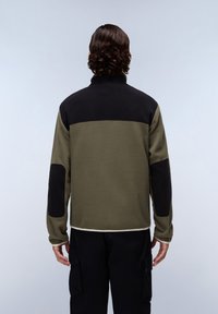 Giacca in pile verde oliva e nera. Presenta un colletto, un design a blocchi di colore, toppe sui gomiti e un'accattivante cucitura a vista all'orlo.