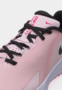 Ροζ αθλητικό παπούτσι Nike με μαύρα κορδόνια, μαύρη εσωτερική επένδυση και κόκκινο κείμενο "INFINITY" στη γλώσσα, με εμφανές λογότυπο Nike swoosh.