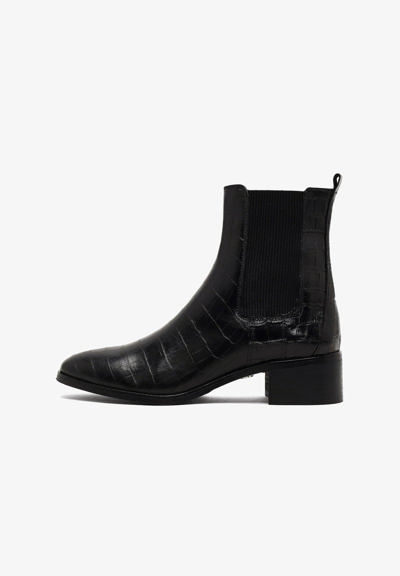 Botines negros hasta el tobillo con textura de cocodrilo, puntera afilada, paneles laterales elásticos y un tacón bajo apilado. Superficie lisa con un diseño elegante.