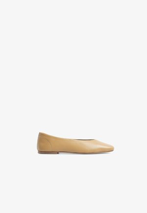 Ballerines en cuir beige avec un bout pointu, au design minimaliste, texture lisse et petit talon plat. Pas de matériel ou de motifs visibles.