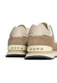 Beige und hellbraune Sneaker aus Wildleder und Leder. Runde Form, strukturierte Akzente und "HOFF"-Logo auf der Ferse.