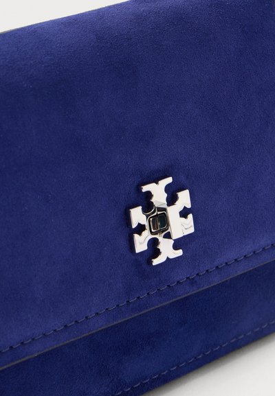 Τσάντα από μπλε σουέτ με λαμπερό ασημί λογότυπο σε σχήμα σταυρού στην μπροστινή πτέρυγα.