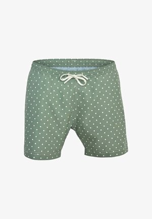 Caleçon de bain vert à pois blancs avec un cordon blanc à la taille élastique.