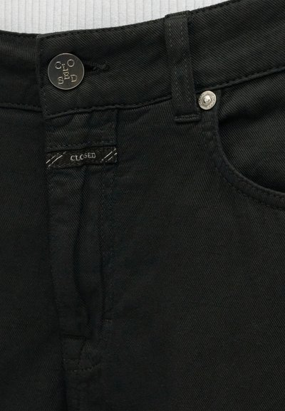 Ceinture de jean en denim noir avec bouton en métal et rivet, avec le logo de la marque "CLOSED" sur le bouton et une petite étiquette près de la poche.