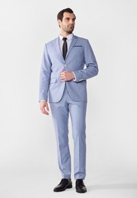 Helles blaues Anzug aus glattem Stoff, bestehend aus einem Ein-Knopf-Blazer und geraden Hosen, kombiniert mit einem weißen Hemd und einer schwarzen Krawatte.