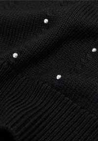 Schwarzer gestrickter Pullover mit geripptem Saum, verziert mit verstreuten klaren Strasssteinen. Weiche Textur, mittelschwere Stoffqualität.