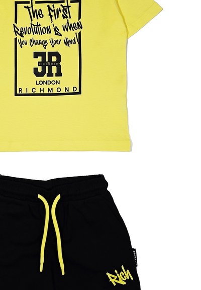 La t-shirt in cotone gialla presenta testo e grafica nera, abbinata a pantaloni corti neri con lacci gialli e ricamo "Rich".