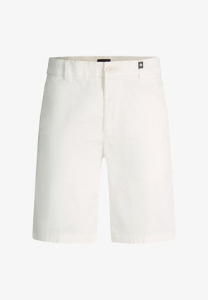 Weiße knielange Shorts mit Knopfverschluss, Gürtelschlaufen und einem kleinen schwarzen Etikett mit weißem Kreuz nahe dem Bund.