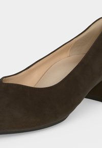 Escarpin femme en daim brun foncé à talon bas, bout arrondi et doublure intérieure beige matelassée.
