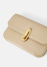 Borsa a busta in finta pelle beige con chiusura dorata, texture liscia, bordi arrotondati e dettagli di cucitura sottili. Design compatto per gli elementi essenziali.
