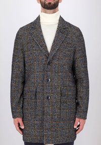 Cappotto in misto lana con motivo a quadri grigio e arancione, colletto a scolla, tre bottoni frontali e tasche laterali. Finitura testurizzata.