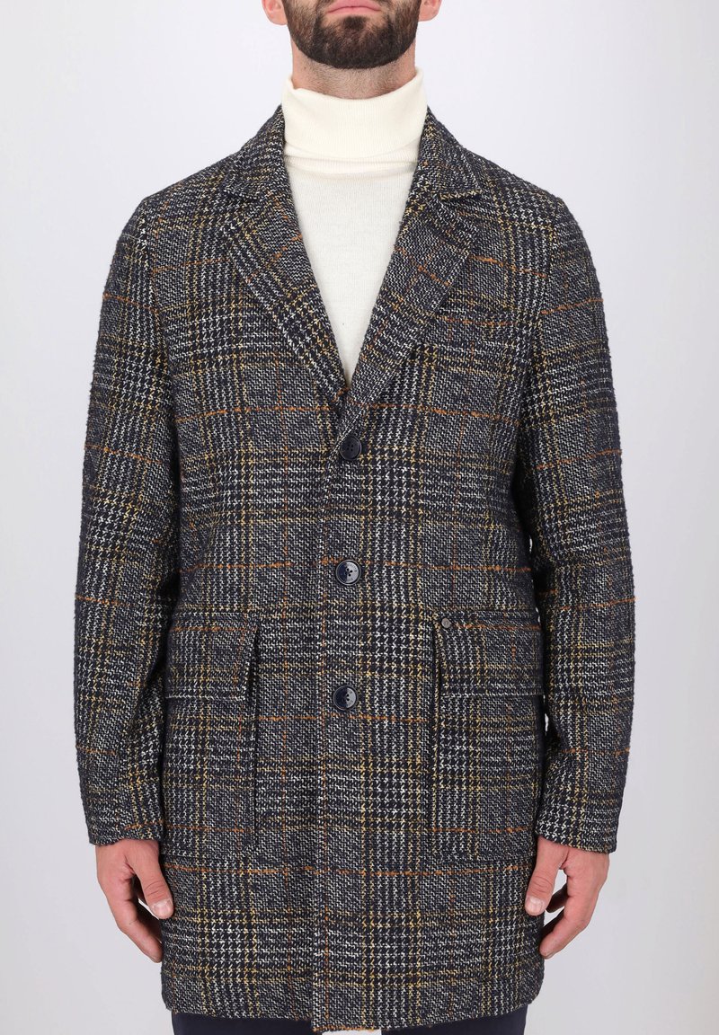 Cappotto in misto lana con motivo a quadri grigio e arancione, colletto a scolla, tre bottoni frontali e tasche laterali. Finitura testurizzata.