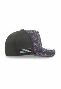 Casquette noire avec un motif éclaboussé multicolore, visière courbée et trous d'aération. Présente une étiquette "Crucial Catch Intercept Cancer".