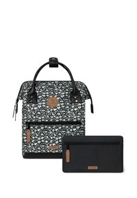 Floral-patterned backpack in black and white with black leather accents, top handle, front pocket, and a black zippered pouch.