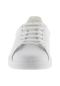 Vit sneaker med perforerade sidopaneler, rund tå och runda snören. Slät läderöverdela, texturerad gummisula och diskret logotyp på tungan.