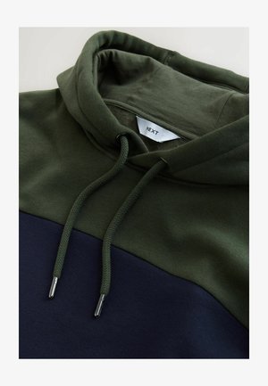 Hætte sweatshirt med en grøn øverste del og en marineblå nederste del. Tekstureret stof, justerbare snore og metalskafter til snorene.