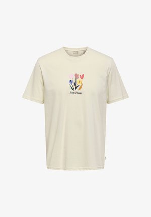 Vaaleanbeige lyhythihainen puuvillapaita. Koristeltu pehmeävärisellä kukkakuviolla, jonka alla teksti "Jardin Parisien".