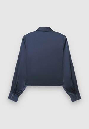 Chemise en satin bleu marine coupée, à manches longues, poignets boutonnés, col classique, présentant une texture lisse et brillante.