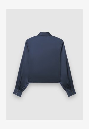 Chemise en satin bleu marine coupée, à manches longues, poignets boutonnés, col classique, présentant une texture lisse et brillante.