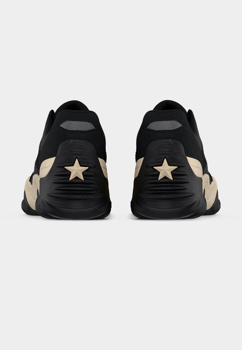 Zwarte sportschoenen met een gestructureerde bovenkant, met een beige accent en een stervormig detail op de hiel. Afrondende silhouet.