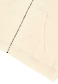 Sudadera con cremallera de color crema claro, con puños y dobladillo acanalados, dos bolsillos frontales y una textura suave y lisa.