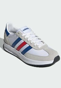 Baskets Adidas pour homme avec une tige en textile blanc, des accents en daim gris, des rayures bleues et rouges, et une semelle en caoutchouc noire. Design classique avec fermeture à lacets.