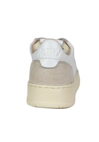 Sneaker bianca e beige con tomaia in suede e pelle, colletto imbottito, logo impresso sul tallone e suola in gomma testurizzata.