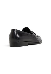 Schwarze Lederloafers mit einer glatten Oberfläche, minimaler Naht, runder Zehenform und einer flachen Sohle. Keine sichtbaren Beschläge oder Akzente.