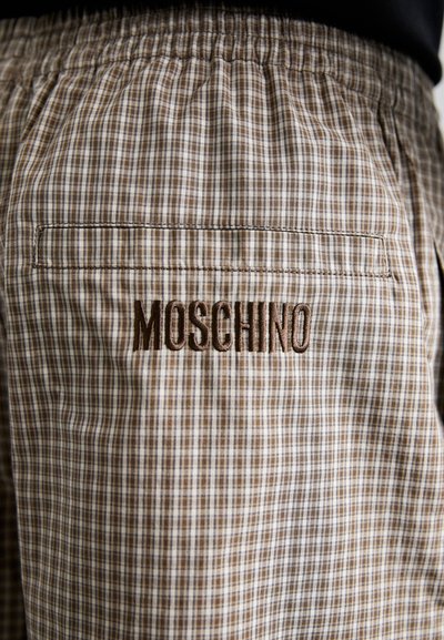 Bruine geblokte shorts met een elastische tailleband, voorzien van een achterzak en "MOSCHINO" geborduurd in bruine draad.