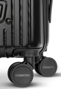 Czarna walizka twarda z teksturowanymi paskami, gładką powierzchnią i solidnymi czarnymi kółkami z napisami "ETERNITIVE" i "PROSTO".