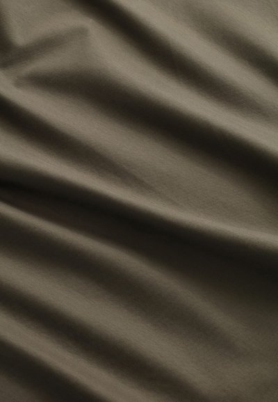 Olijfgroene stof met een gladde textuur, met subtiele vouwen en kreukels, kenmerkend voor lichtgewicht materiaal.