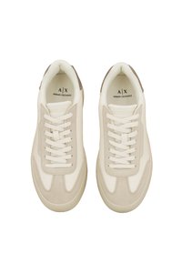 Zapatillas blancas con detalles de ante beige, con un diseño texturizado, cordones planos y marca en la plantilla interior.