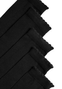 Černé bavlněné ponožky s žebrovaným vzorem a vlnitými okraji, uspořádané v překrývajících se vrstvách, ukazující hladkou strukturu.