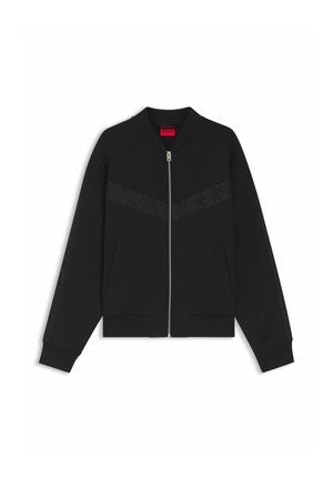 Veste bomber noire zippée avec poignets et ourlet côtelés, bandes texturées inclinées sur la poitrine et les manches, et poches latérales.