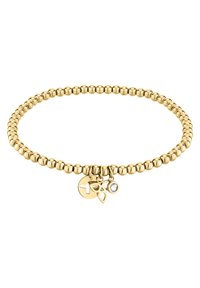 Gouden kraal elastische armband met drie bedels: een ronde schijf, een bladvorm en een heldere edelsteen, wat visueel belang en detail toevoegt.