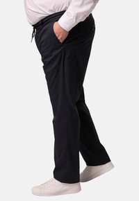 Námořnické volnočasové kalhoty s elastickým pasem a stahovací šňůrkou, obsahující boční kapsy a uvolněný střih, doplněné bílými teniskami.