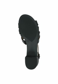 Fekete magassarkú szandál texturált gumitalppal, állítható bokapánttal és kontúrozott sarokkal a stabilitás érdekében. Simább felső anyaggal rendelkezik.