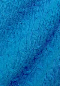 Grober Strickpullover in leuchtendem Blau, mit einem strukturierten Muster aus ineinandergreifenden Linien, aus weichem, dickem Garn mit glatter Oberfläche.