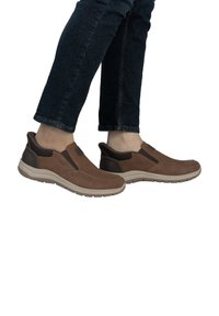 Scarpe slip-on marroni realizzate in suede e materiale sintetico, con pannelli laterali elasticizzati, punta arrotondata e suola leggera in gomma.