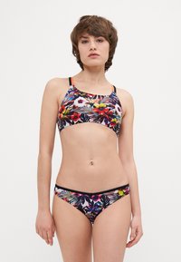 Bikini floral aux couleurs vives sur fond sombre. Le haut présente des bretelles avec des accents orange ; le bas a des côtés étroits et un motif assorti.