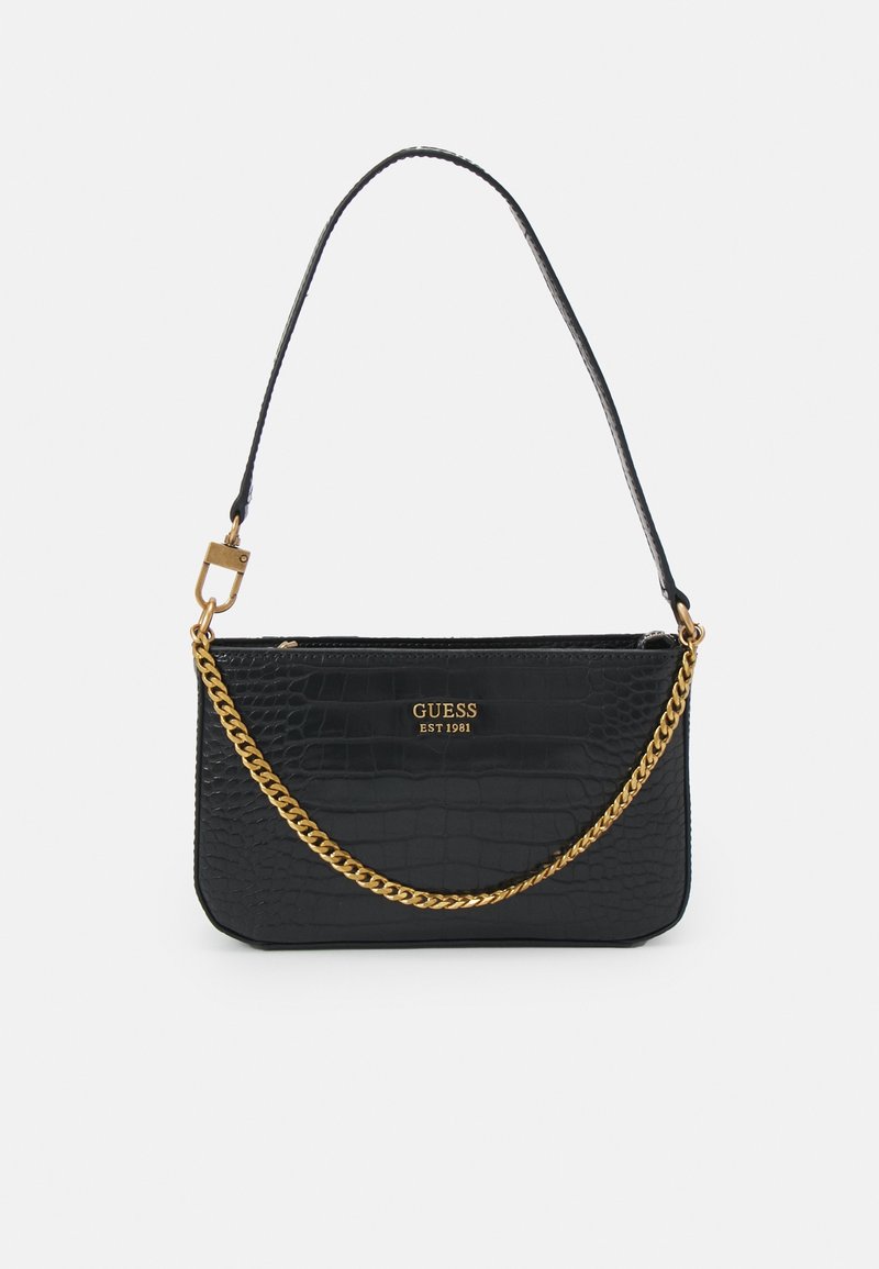 Sac à main Guess noir à motif crocodile, détail chaîne dorée et fine bandoulière, logo et "EST 1981" en doré sur le devant.
