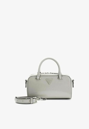 Petit sac à main gris avec double poignée, bandoulière amovible et un logo triangulaire Guess sur le devant.