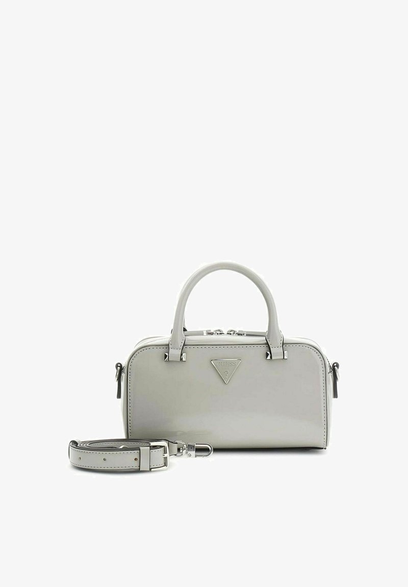 Petit sac à main gris avec double poignée, bandoulière amovible et un logo triangulaire Guess sur le devant.