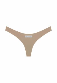 Beige tanga s hladkým povrchem, s nízkým pasem a malou cedulkou s nápisem "GOD SAVE QUEENS" na přední straně.