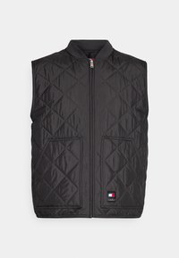 Svart quiltad väst med hög krage, frontdragkedja och två sidofickor. Har en liten logotyp på nedersta högra sidan. Slät textur.