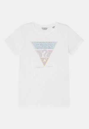 T-shirt blanc à manches courtes avec un design triangulaire clouté comportant le mot "GUESS" et un point d'interrogation sur le devant.