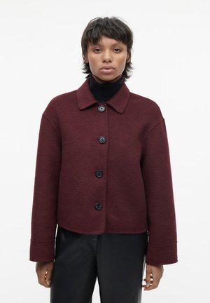 Bordeaux wolmix jas met een kraag, zwarte knopen, een cropped ontwerp en wijde mouwen, gecombineerd met een zwarte coltrui.