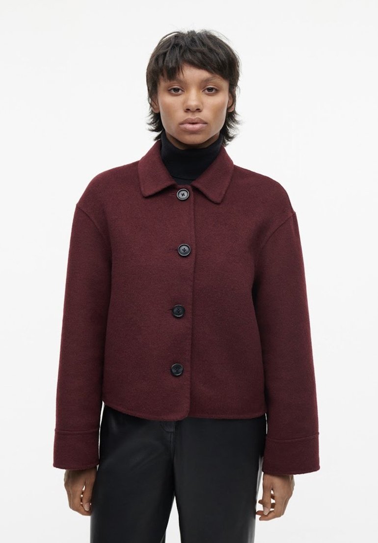 Bordeaux wolmix jas met een kraag, zwarte knopen, een cropped ontwerp en wijde mouwen, gecombineerd met een zwarte coltrui.
