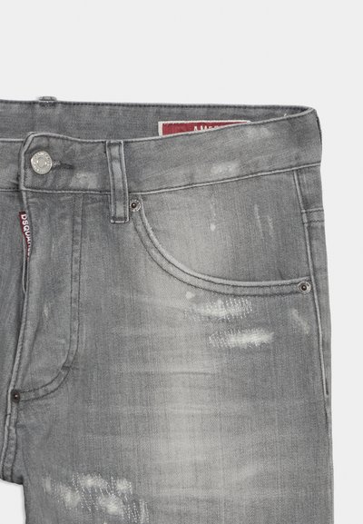 Jean en denim gris avec poche avant, passants pour ceinture, bouton en métal et détails usés décolorés.