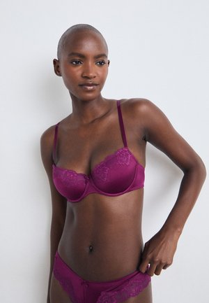 Lila BH mit Spitzendetails, Unterdraht, verstellbaren Trägern und passenden Bikinihöschen. Glattes Material und zarte Musterdetails.